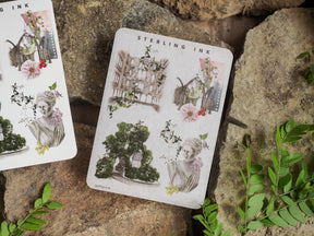 Decorative sheet featuring antique icon stickers of botanical illustrations, classical portrait busts, and ornate architectural arches in soft, vintage tones.