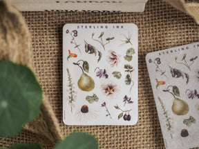 Decorative sticker sheet featuring a collection of soft botanical illustrations, including ripe pears, delicate blush-toned flowers, and various lush leaves.