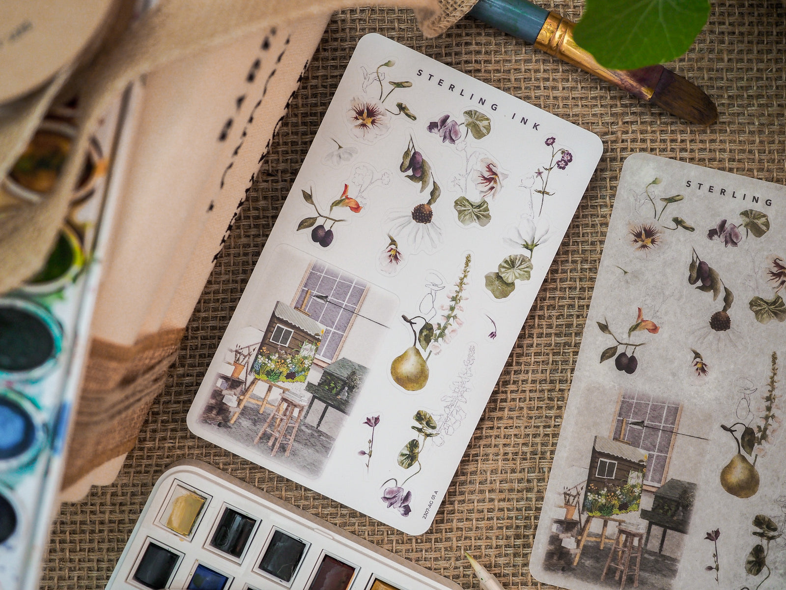 Botanical sticker sheet featuring delicate floral arrangements, realistic drawn plants, berries, and a charming rustic house illustration for July 2023 scrapbooking and journaling.