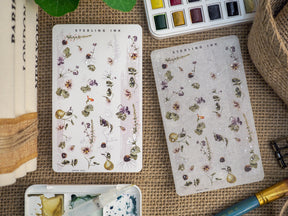 Delicate botanical sticker sheets featuring watercolor illustrations of mixed florals, lush greenery, and small berries, ideal for seasonal journaling and scrapbooking.