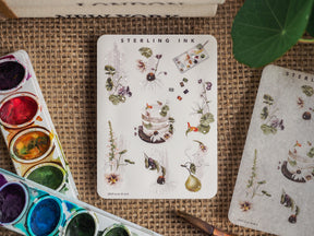 Botanical icon sticker sheet featuring detailed watercolor illustrations of flowers, plants, and baked goods with delicate silver foil accents.