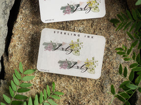 Elegant pastel stickers for July planning, featuring the month name surrounded by delicate watercolor florals in muted greens and soft blush pink.