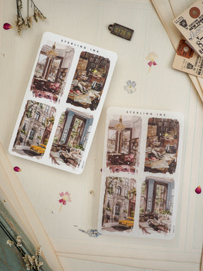 Two "STERLING INK" sticker sheets featuring four-panel illustrated grids of nostalgic European scenes, showcasing bustling cafe interiors and charming old city streets.