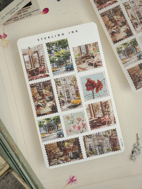 Sterling Ink sticker sheet featuring a grid of vintage postcards depicting detailed, charming scenes of historic city streets, old architecture, and classic urban life.