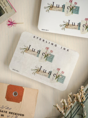 Vintage stationery featuring a "STERLING INK" design with delicate floral stamps and "july" postage motifs, perfect for journaling or scrapbooking.