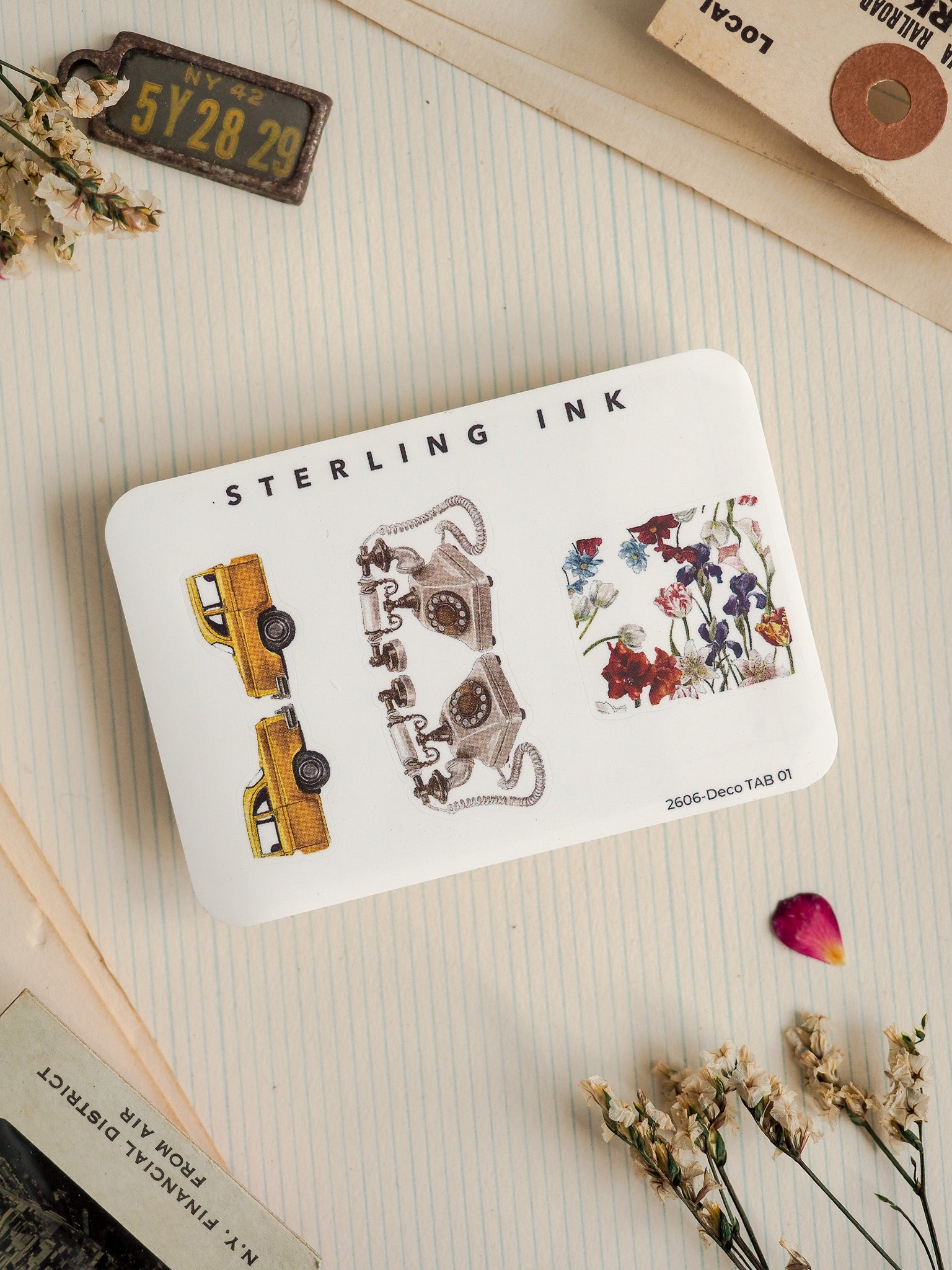 Sterling Ink sticker set featuring a vintage arrangement of designs, including a yellow classic car, an ornate antique machine illustration, and a delicate bouquet of wildflowers.