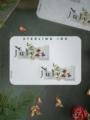 Decorative July month stickers featuring a delicate botanical design, soft watercolor purples, and lovely floral accents perfect for journaling and scrapbooking.