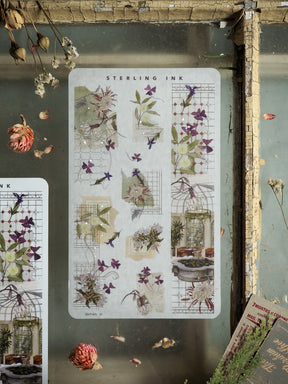 Vertical washi strip stickers displaying delicate watercolor botanical art, featuring clusters of purple lilacs, varying green foliage, and detailed floral arrangements.