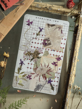 Elegant vintage "Sterling Ink" deco sheet featuring botanical motifs, soft floral prints, and academic-style grid lines in muted purples, sage green, and cream.