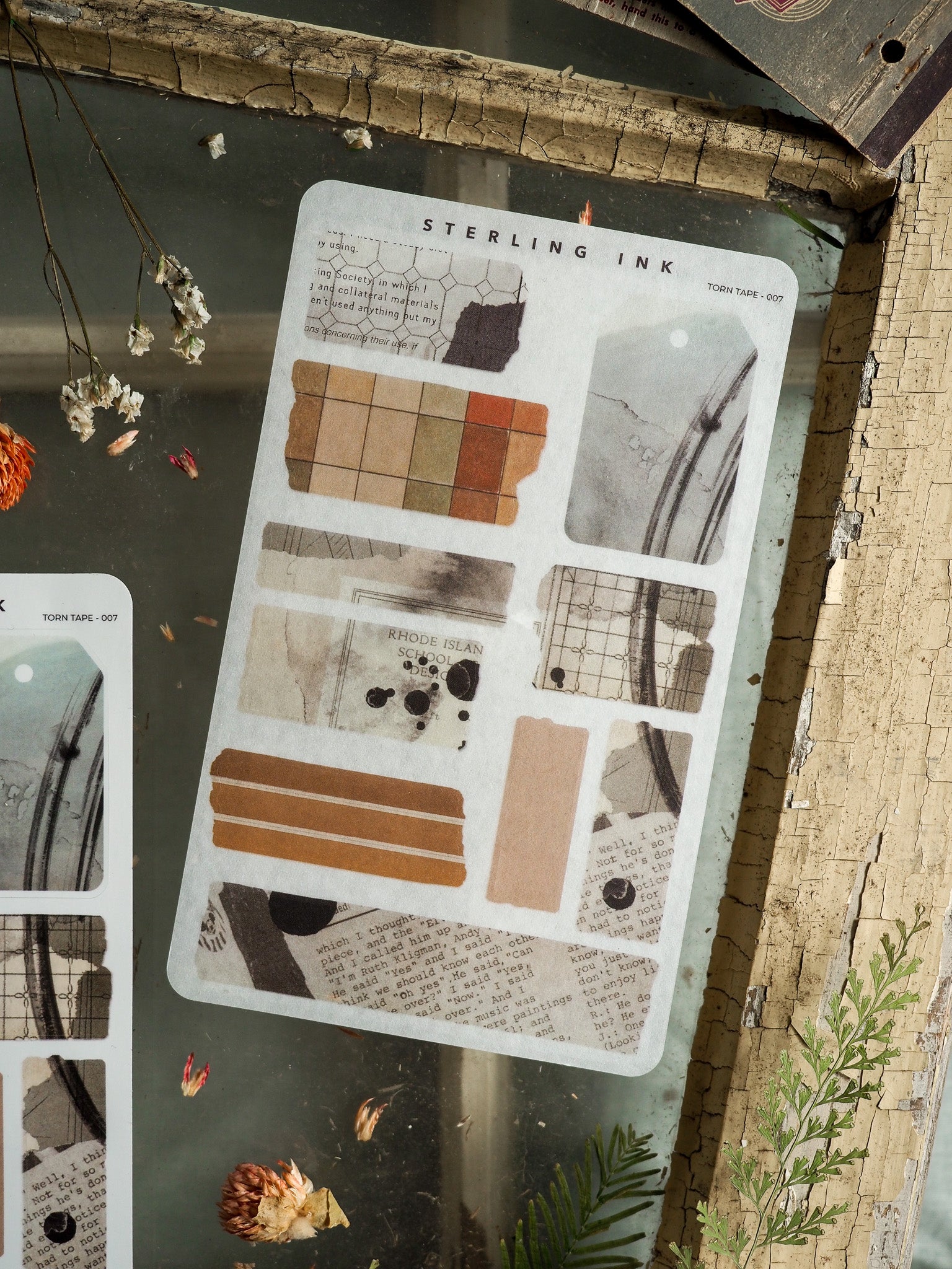 Scrapbook-ready adhesive sheet featuring vintage-toned, torn-edge strips in beige, brown, and slate gray, decorated with "Sterling Ink" designs.