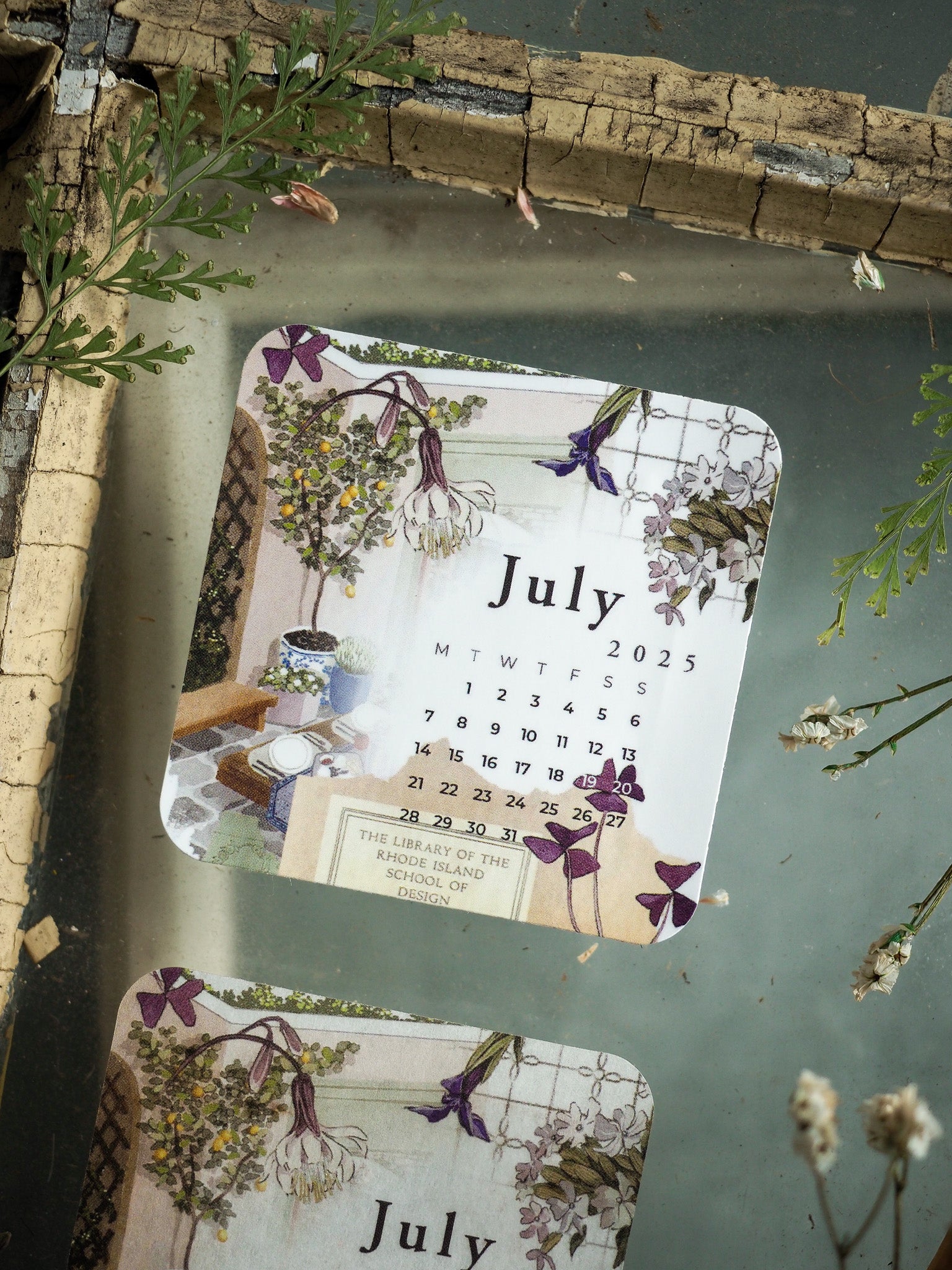Botanical monthly calendar page for July 2025, featuring a delicate, vintage design surrounded by pastel illustrations of purple and white wildflowers.