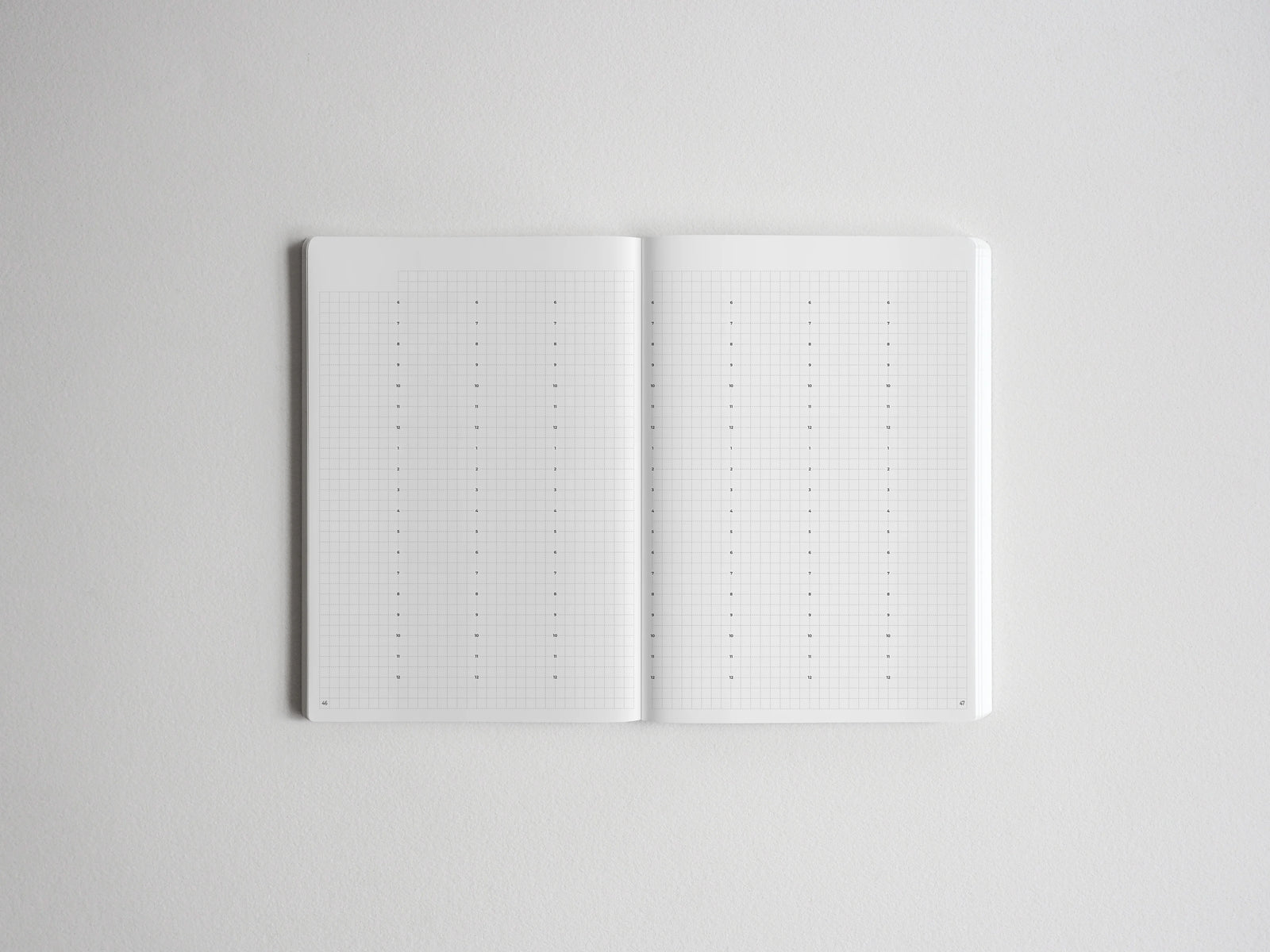 Open notebook displaying two pages of precise dotted grid paper, ideal for bullet journaling, planning, and creative note-taking.