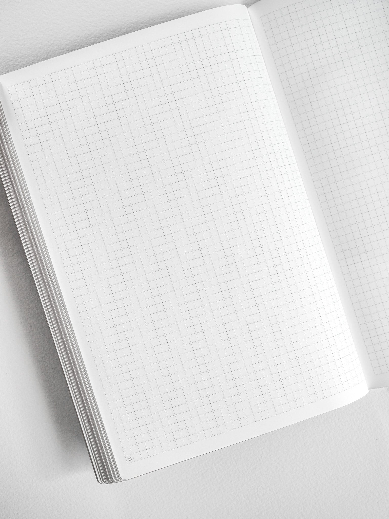 Open A5 graph paper notebook booklet featuring neatly gridded white pages, ideal for technical drawing, journaling, or structured note-taking.