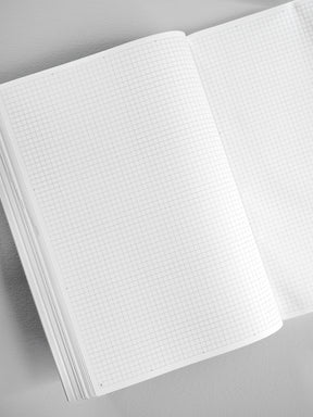 An open B5 booklet reveals uniform graph grid paper across its pages, designed for structured note-taking, planning, or journaling.