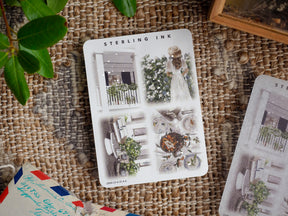 A sheet of large, illustrative die-cut stickers featuring silver foil accents and romantic themes like detailed garden decor, patio scenes, and whimsical floral designs.
