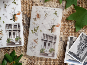 Delicate sticker sheet featuring elegant vintage architecture, potted greenery, and scattered autumnal foliage rendered in a charming, muted watercolor style.