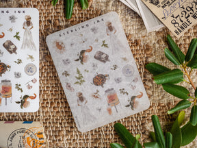 Detailed mini sticker sheets featuring a pattern of nature elements, including insects, florals, and rustic icons, in muted, vintage tones.
