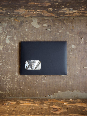 Minimalist dark gray subscription kit packaging featuring a subtle vertical graphic detail on the front cover.