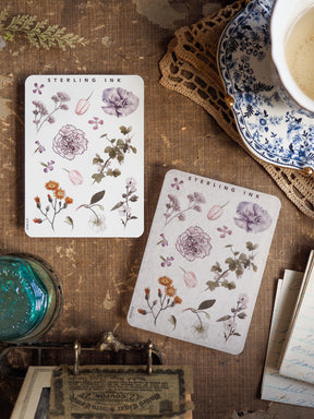 Delicate watercolor-style botanical elements adorn these sheets, featuring pastel purple, pink, and green floral clusters perfect for crafting.