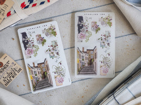 Whimsical sticker set featuring watercolor illustrations of quaint city storefronts and abundant floral arrangements, perfect for August 2024 decorating.