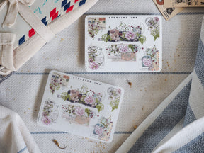 Decorative sheets of elegant corner stickers featuring muted botanical designs, blush pink roses, and greenery, branded by Sterling Ink.