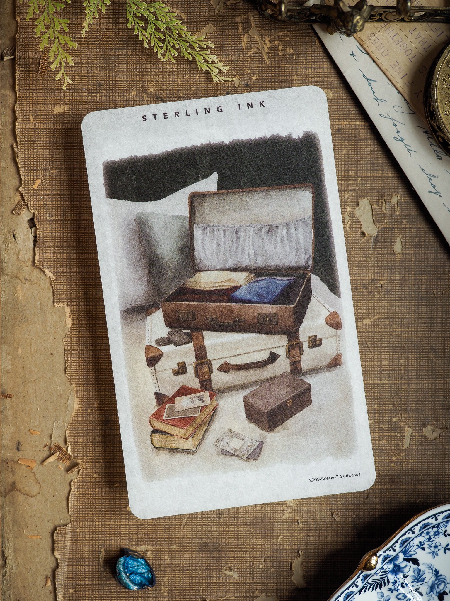 Single scene sticker featuring a sepia illustration of stacked, vintage brown suitcases and travel trunks, ideal for scrapbooking or journaling.
