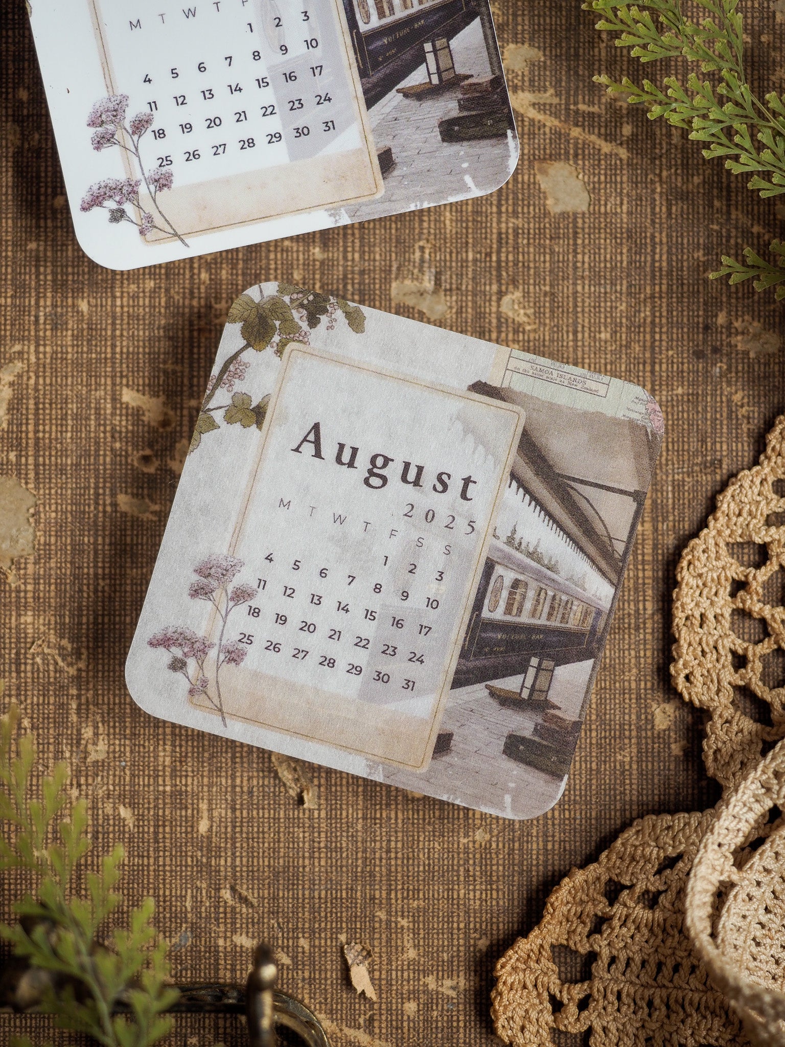 Rustic August 2025 monthly calendar featuring a vintage sepia background and an integrated photograph of a classic European street facade.