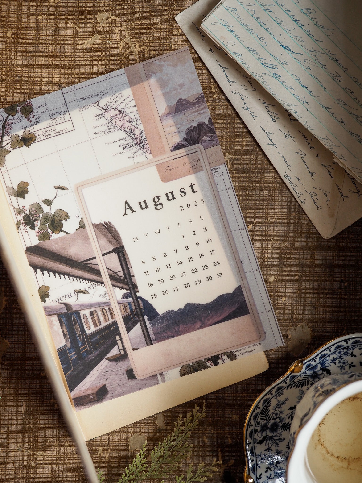 August 2025 B6 monthly calendar designed with a vintage train station photograph and subtle travel-themed map elements.