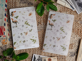 Delicate botanical sticker sheet featuring watercolor illustrations of wildflowers, leaves, and dried herbs, perfect for journaling and scrapbooking embellishments.