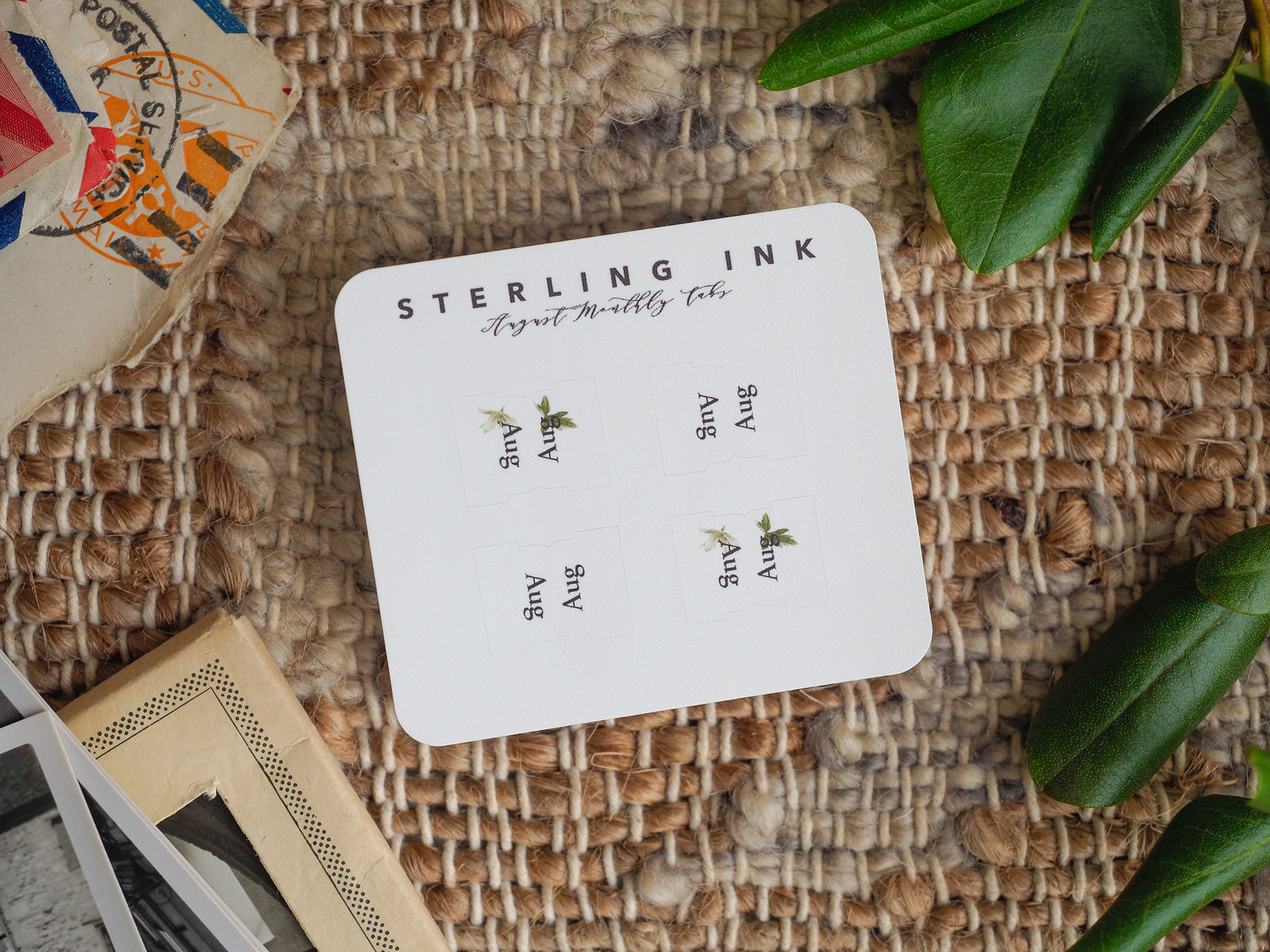White August monthly planner tab featuring "STERLING INK" title and four small, elegant botanical leaf designs for organization.
