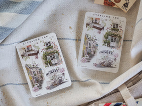 Vintage sticker set featuring detailed illustrations of romantic European street scenes, showcasing quaint Parisian buildings, striped awnings, and lush floral details.