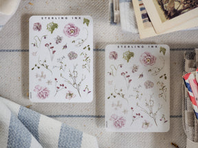Botanical sticker sheet set from Sterling Ink featuring delicate pressed florals, including pink roses and assorted green woodland foliage.