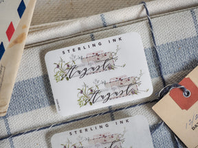 Rustic August month sticker by Sterling Ink, designed with delicate blush florals and vintage accents for journaling and planning.