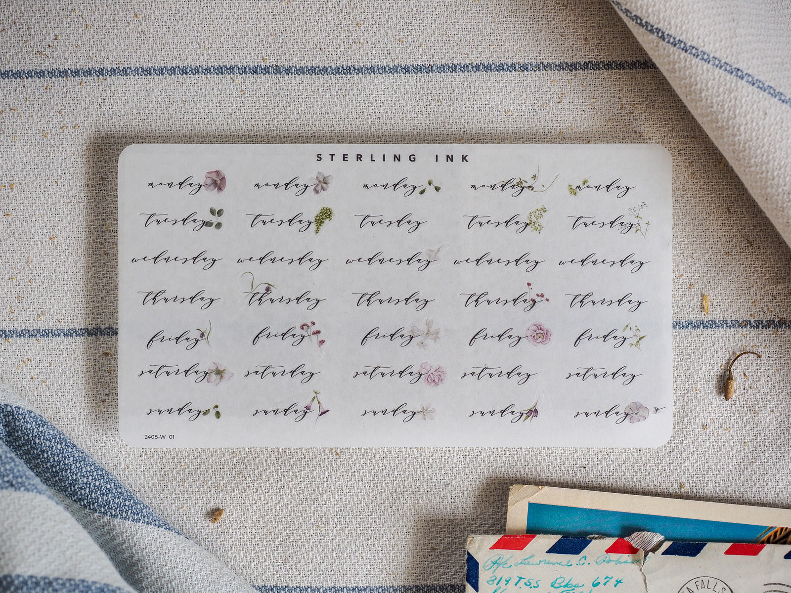 Whimsical sheet of hand-lettered labels in muted sepia ink, showcasing all seven days of the week for August 2024.