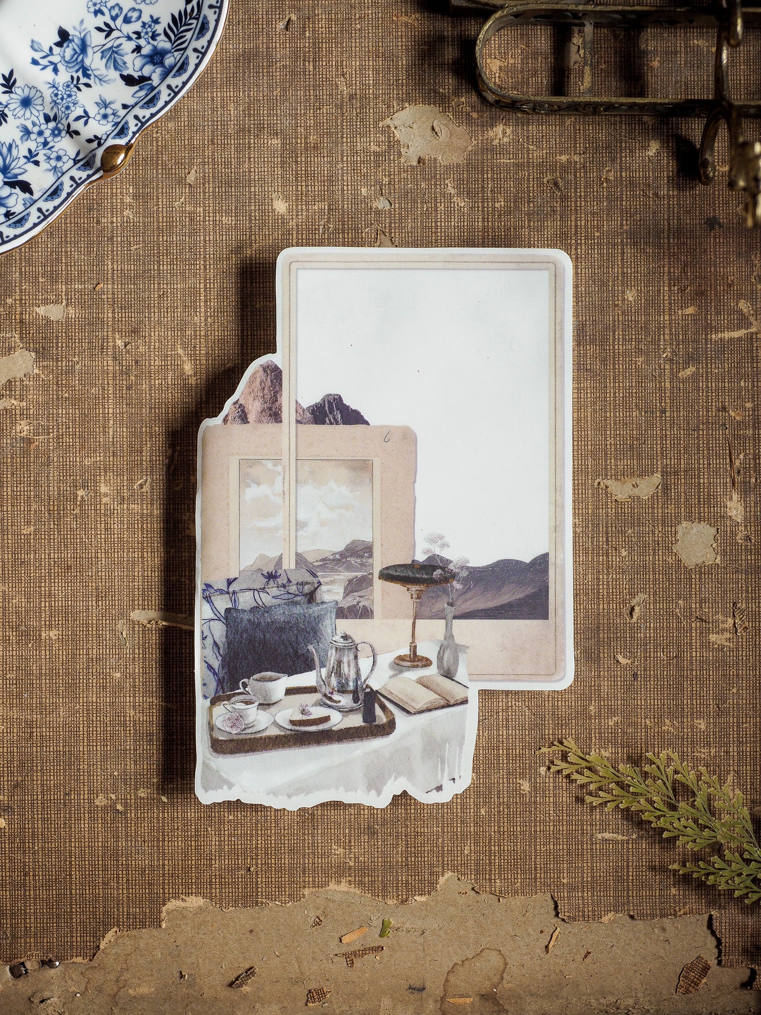 Creamy vintage sticker featuring a delicate watercolor blend of teacups, antique accessories, and a distant mountain landscape for August 2025 planning.