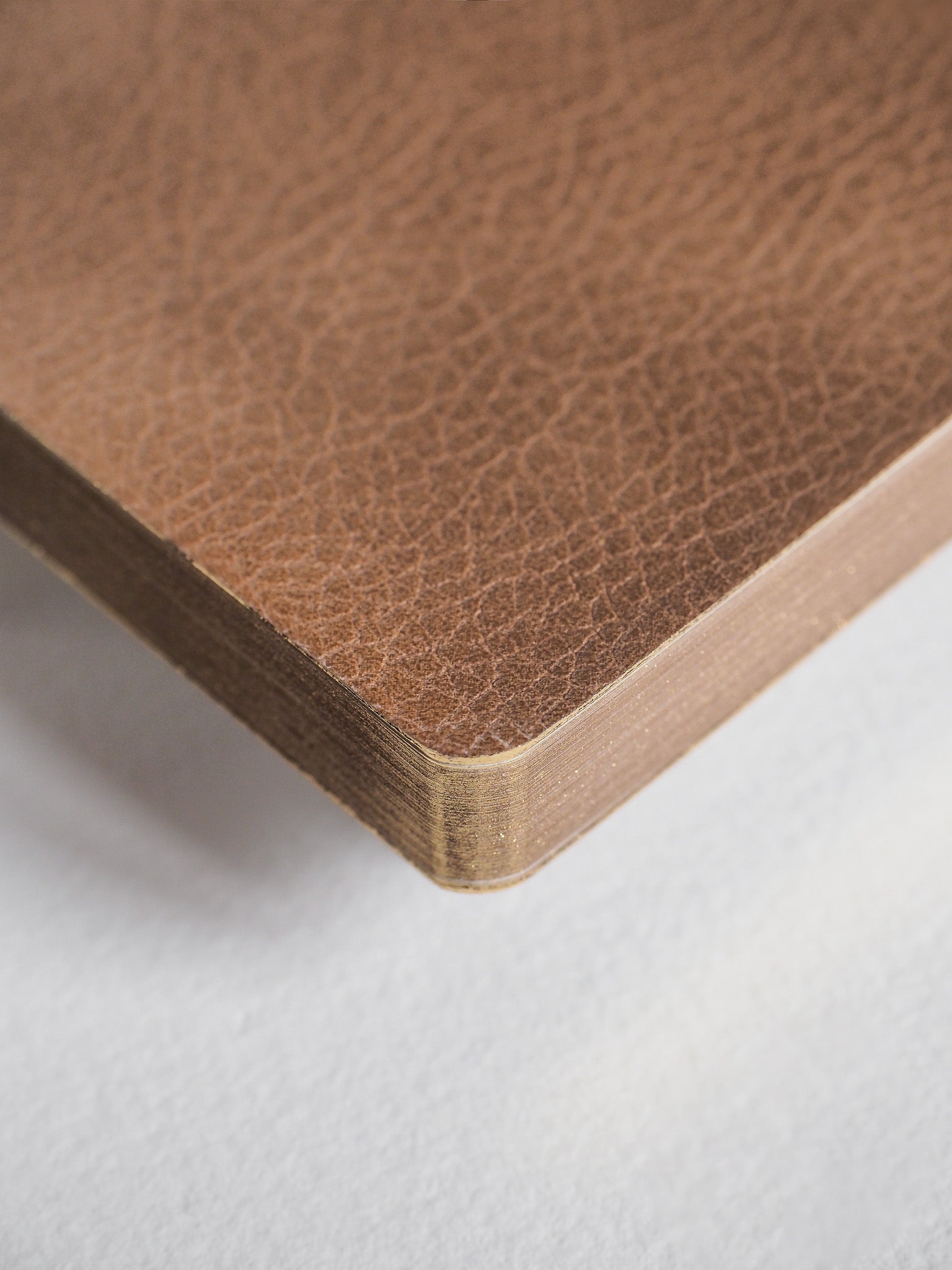 Structured A6 notebook featuring a deep, textured cocoa brown cover and substantial visible edges, ready for grid note-taking.