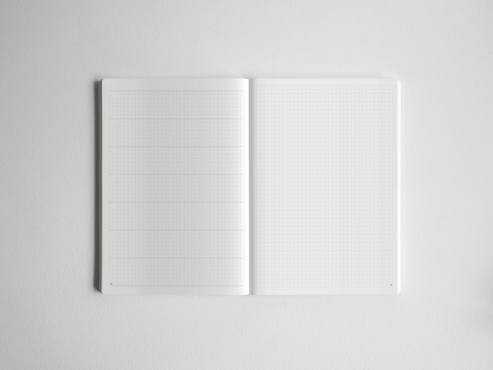 Open notebook featuring light-ruled graph paper on both sides, providing structured grid lines perfect for planning, sketching, or academic note-taking.