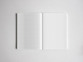 Open notebook featuring light-ruled graph paper on both sides, providing structured grid lines perfect for planning, sketching, or academic note-taking.