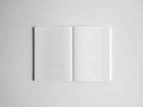 Open notebook displaying two pristine pages covered in a precise, light-colored graph paper grid, ideal for sketching, drafting, or structured note-taking.