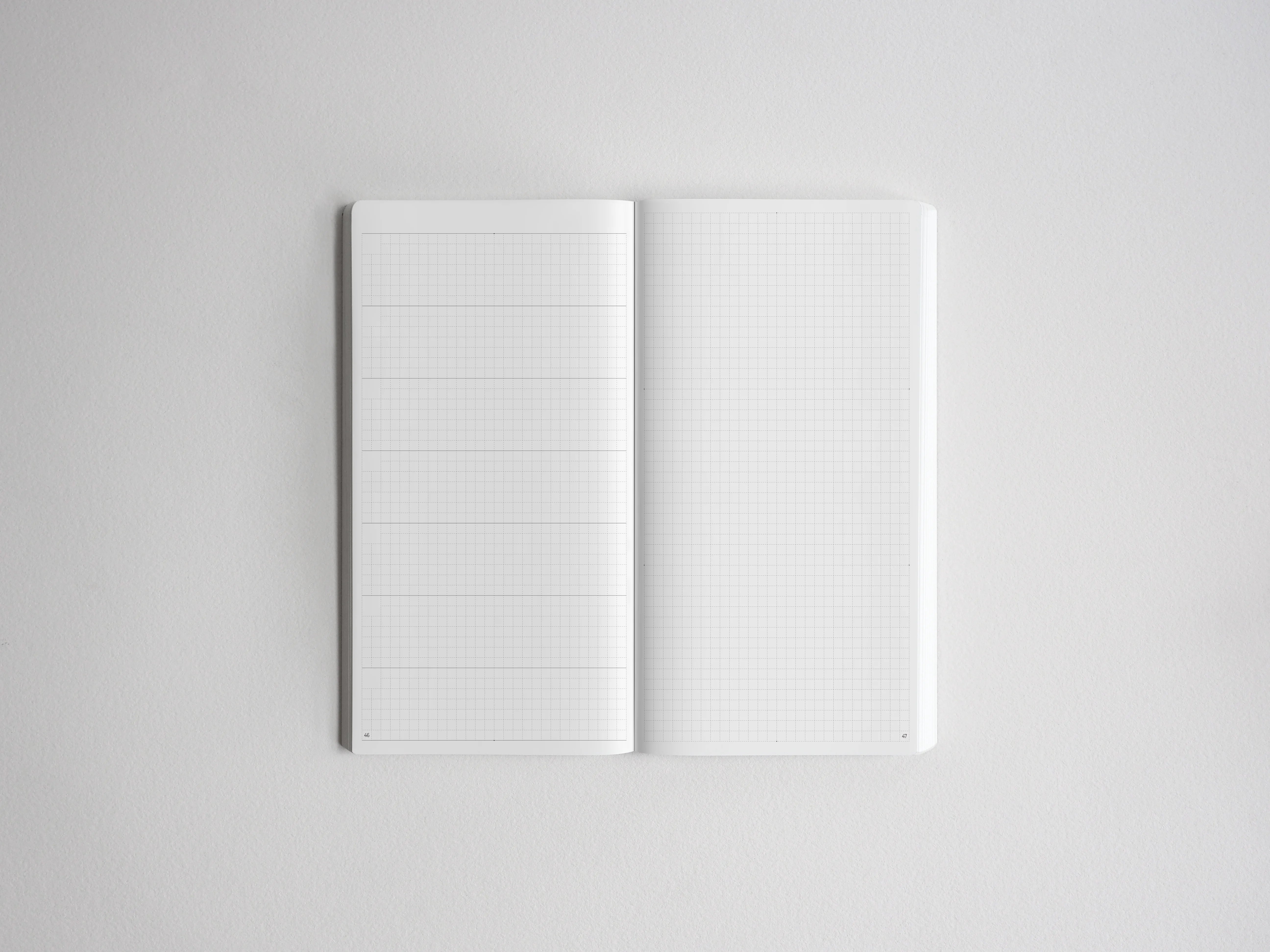 Open notebook featuring two pages of light gray graph paper, ideal for drafting, drawing, charting, or technical note-taking.