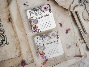Decorative September 2024 monthly calendar featuring a romantic floral wreath border in muted shades of lilac, blush pink, and deep green.