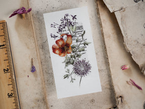 Die-cut vinyl sticker featuring a vintage botanical illustration of lilies, thistle, and labeled foliage for academic or autumnal journaling.