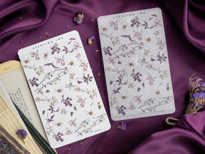 Elegant sticker sheets featuring a delicate, vintage botanical pattern of small flowers and leaves in muted mauves, creams, and dusty purples.