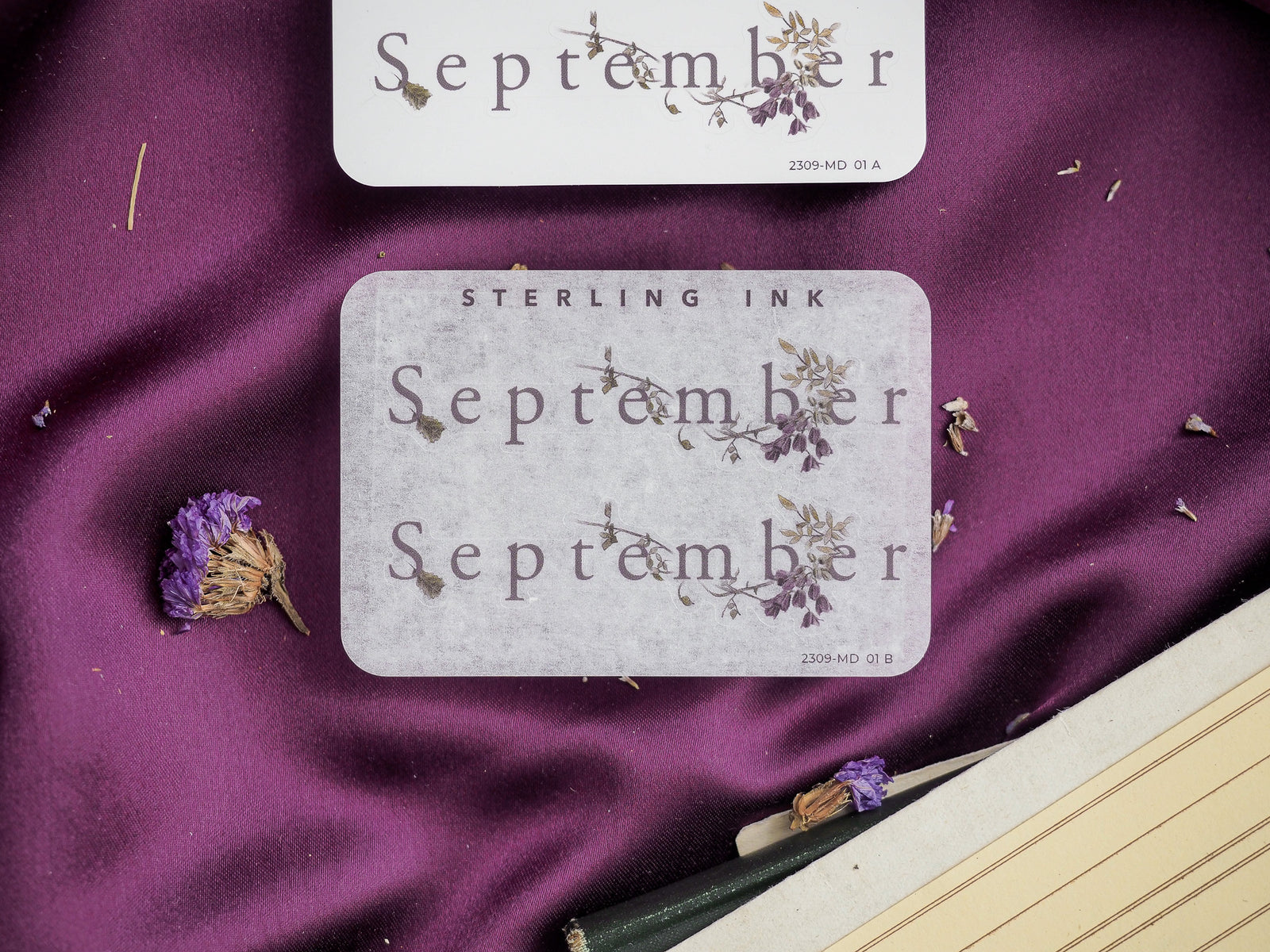 Pale gray decorative sticker set for September featuring the month name and delicate wreaths of dried botanical illustrations.