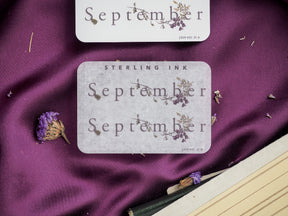 Pale gray decorative sticker set for September featuring the month name and delicate wreaths of dried botanical illustrations.