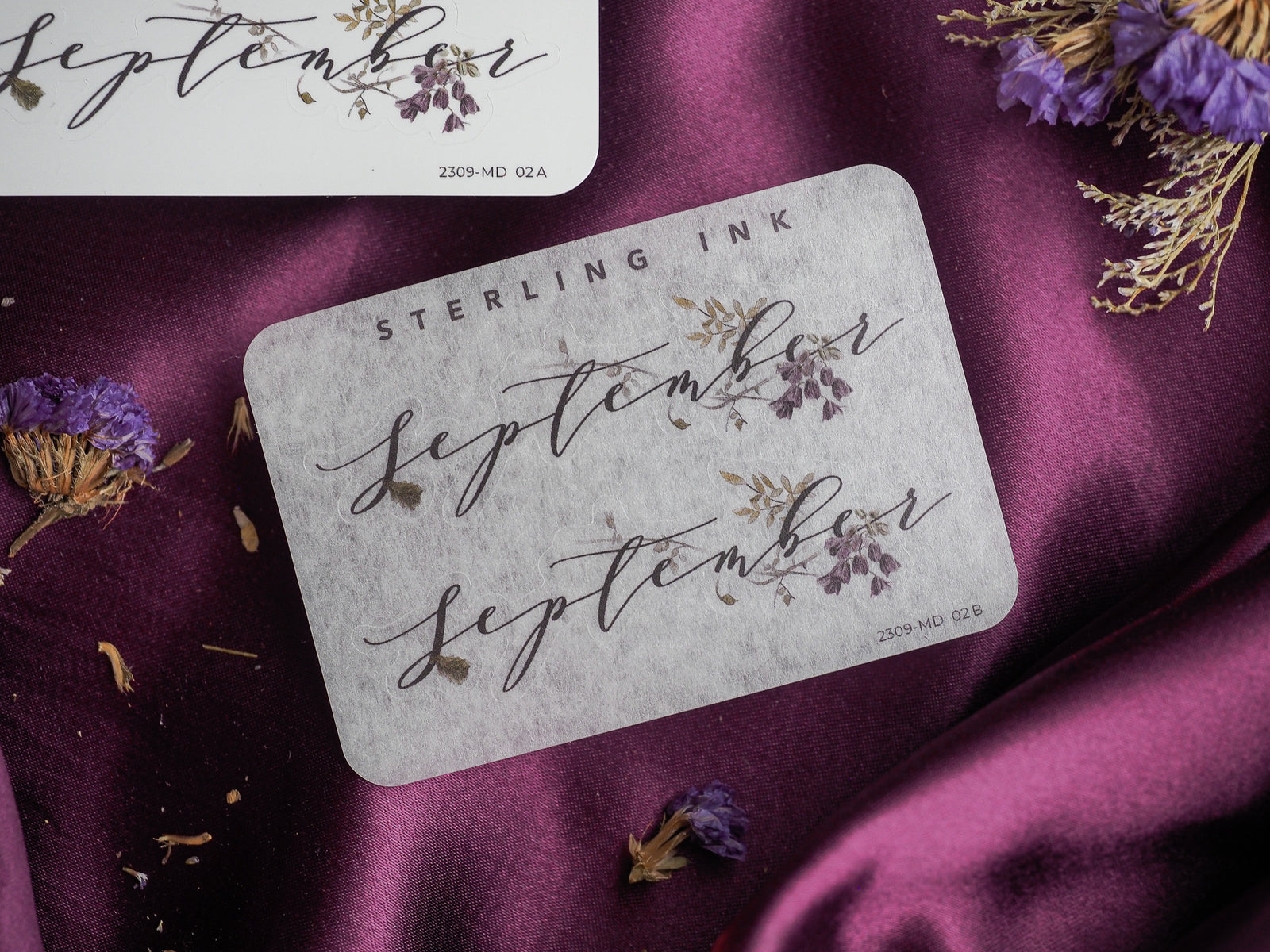 Elegant September month sticker featuring delicate, brown calligraphy and surrounding sepia-toned botanical wreath designs for journaling or scrapbooking.