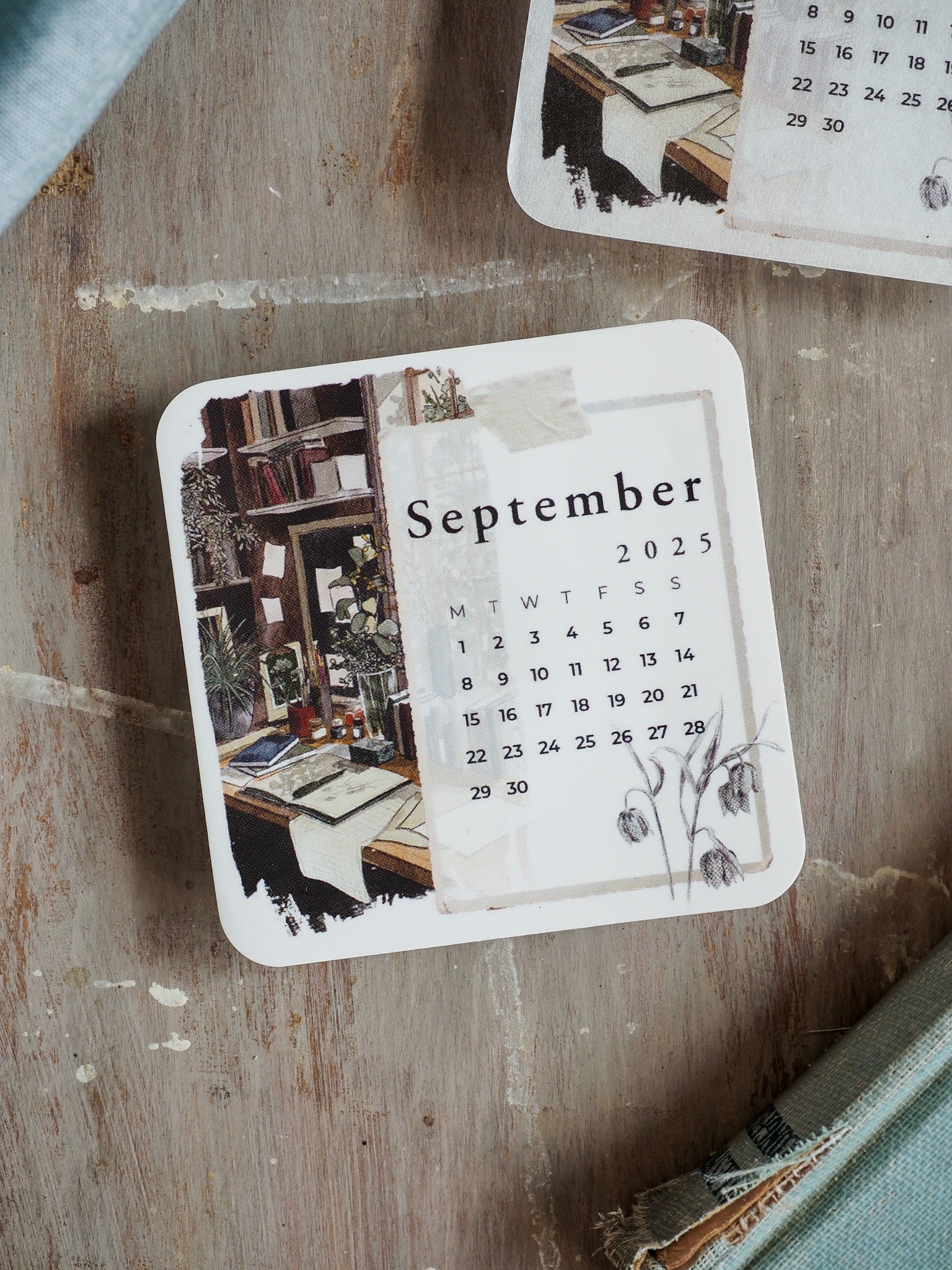 September 2025 monthly calendar featuring a cozy image of filled bookshelves and a clean grid with delicate drawn floral accents.