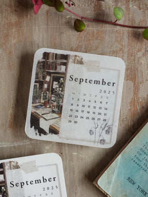 September 2025 monthly calendar featuring a charming, sepia-toned sketch of a vintage urban street scene above a clear date grid.