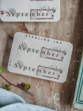 Vintage September month sticker featuring distressed lettering and a delicate botanical border, perfect for seasonal journaling or scrapbooking.