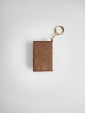 A brown textured leather card holder keychain with a gold-tone split ring and chain, shown on a light gray background.
#Color_Caramel